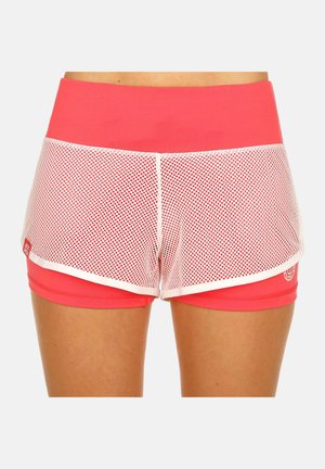 Femme portant un short de sport rose corail avec un filet blanc en superposition et une taille haute, montrée de la taille jusqu'à la mi-cuisse.