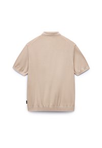 Polo shirt beige a maniche corte con tessuto testurizzato, colletto e orlo a coste, dotato di maniche raglan e un piccolo tag del marchio sul lato.