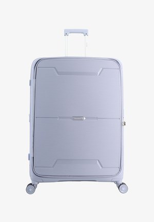 Large light blue hard-shell suitcase with horizontal ridges, four wheels, extended telescopic handle, and Saxoline brand label center front.