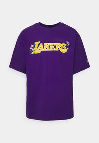 Fialové bavlněné tričko s krátkými rukávy a kulatým výstřihem. Na levé straně má žluté logo "LAKERS" a květinové detaily.