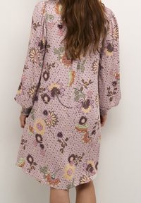 Vestido midi floral en púrpura pastel con mangas largas. Presenta intrincados patrones florales en amarillo, verde y marrón sobre una tela ligera.