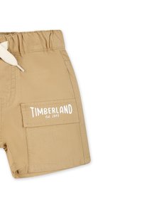 Bermuda khaki realizzati in tessuto con una superficie liscia, caratterizzati da un logo bianco, una vita elasticizzata e una tasca laterale con pattina.