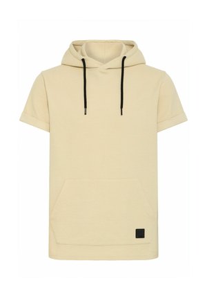 Short-sleeve, beige hooded pullover made of textured fabric, featuring a front pocket and black drawstring for the hood. Black logo patch on the hem.