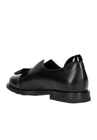 Zwarte leren schoen met een ronde neus, uitsnedes aan de zijkanten en een glanzende zwarte hak. Gladde textuur met minimale hardware-accenten.
