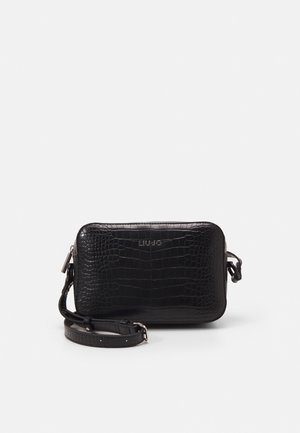 Bolso bandolera rectangular negro con textura de cocodrilo, cremallera plateada y correa ajustable, nombre de la marca grabado en el centro frontal.