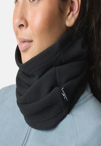 Black fleece neck gaiter, soft texture, tucked design, worn close to the neck, with a small logo tag visible on the side.