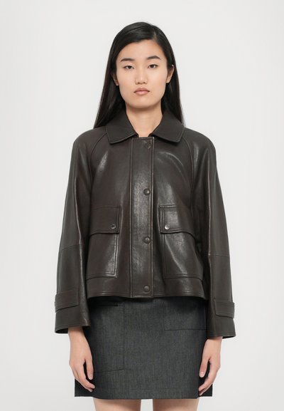 Veste en cuir brun foncé avec un col, fermeture à boutons sur le devant et deux poches avant. Présente une coupe structurée et une texture lisse.
