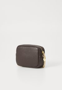 Bruin leren ritsportemonnee met een gestructureerd oppervlak, rechthoekige vorm, goudkleurige hardware en een kettingaccent aan de rits.