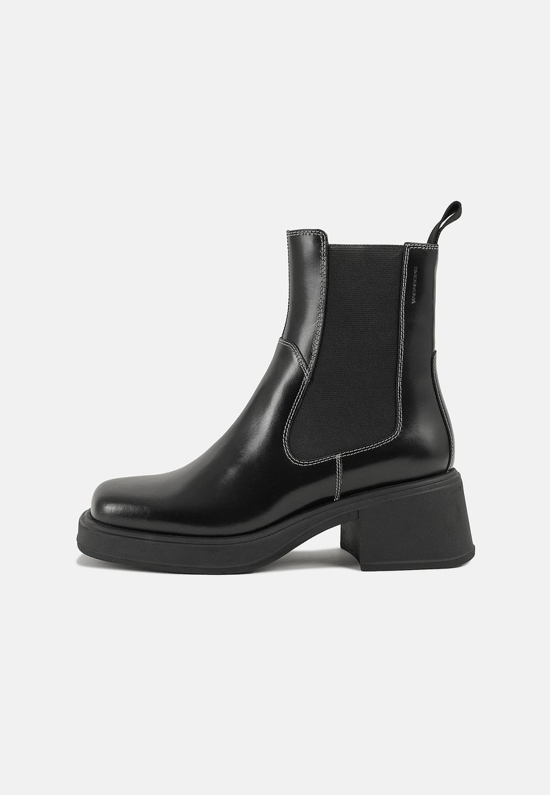 Bottine en cuir noir avec des panneaux latéraux élastiques, bout rond et talon bloc. Présente une couture blanche contrastante et une languette.
