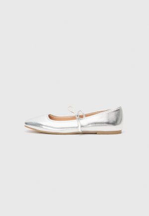 Scarpa piatta argento con punta affusolata, realizzata in materiale sintetico metallico. Presenta una sottile tracolla con un fiocco decorativo. Texture liscia.