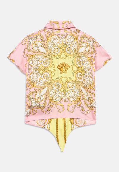 Majica s kratkim rukavima u nijansama ružičaste i žute boje. Sadrži složene zlatne barokne uzorke i dizajn s oštrim rubom. Glatka, svilenkasta tekstura.