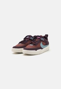 Tenisice sa gornjim dijelom od maroon mreže i suedinim akcentima, svijetloplavi Swoosh i teksturirana bijela potplat sa mrljama.