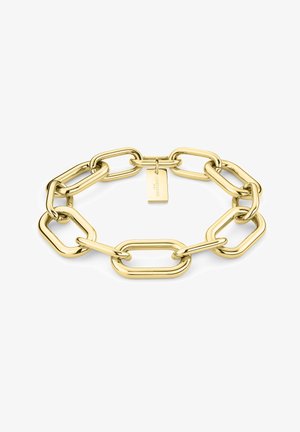 Bracelet en chaîne dorée avec des maillons ovales allongés et une texture lisse, accompagné d'une petite étiquette suspendue gravée du nom de la marque.