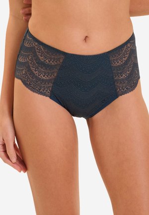Woman wearing dark blue lace high-waisted underwear, showing front and sides with scalloped lace patterns.