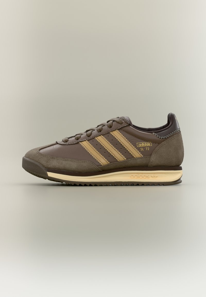 Smeđe kožne i antilop sportske cipele s tri bež pruge, okruglim vrhom, teksturiranim detaljima i bež gumenim đonom.