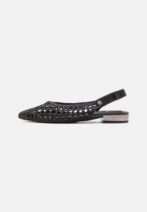 Zapato negro de slingback tejido con punta afilada, tacón bajo y bloque, y herrajes metálicos decorativos. Material texturizado con detalles recortados.