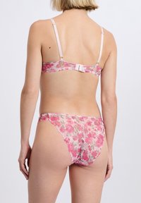 Spitzenwäsche-Set in rosa Blumenmuster mit verstellbaren Trägern und Hakenverschluss, versehen mit zarten, gezackten Kanten und transparenter Textur.