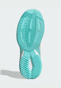 Podeszwa sportowego buta wykonana z teksturowanej, turkusowej gumy z rowkami i żebrowaniem dla lepszej przyczepności. Białe akcenty w okolicach pięty. Konstrukcja nie pozostawiająca śladów.