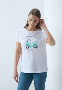 Vit t-shirt i bomull med en turkos scooter grafik och glittriga detaljer, samt texten "AMORE MIO" och "ITALY" tryckt ovanför.