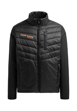 Chaqueta negra con frontal acolchado, cuello alto y logo naranja "CAMP DAVID". Presenta un bolsillo en el pecho con cremallera y mangas de tela suave.