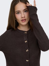 Braune Strickjacke mit rundem Halsausschnitt, langen Ärmeln, goldfarbenen, schleifenförmigen Knöpfen und strukturiertem Stoff.