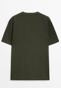 Oliwkowy T-shirt z krótkim rękawem o okrągłym dekolcie. Wykonany z gładkiej bawełnianej tkaniny. Prosty fason bez widocznych wzorów czy akcentów.