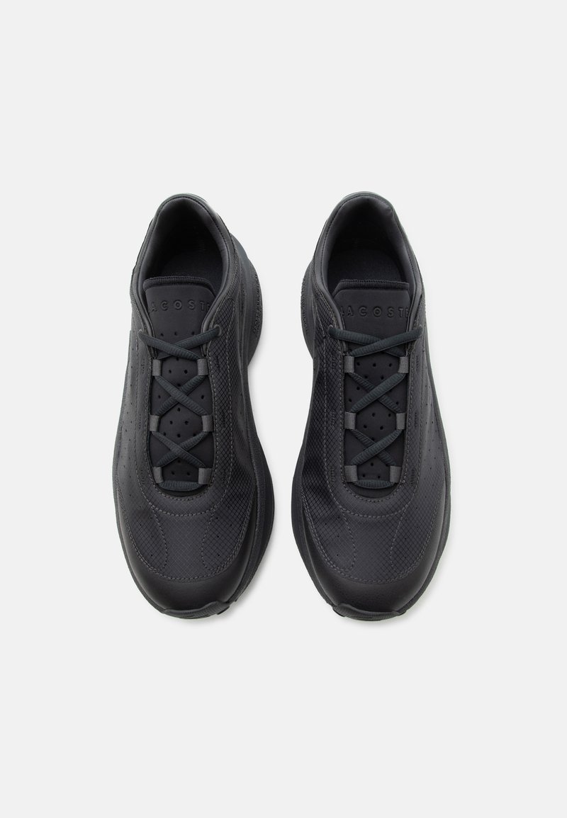 Coppia di sneakers nere basse con lati testurizzati e lacci incrociati, viste dall'alto su uno sfondo bianco.