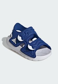 Granatowe sandały z teksturowaną syntetyczną cholewką, regulowanymi paskami i białą podeszwą. Posiadają wycięcia oraz gumową podeszwę zewnętrzną dla lepszej przyczepności.