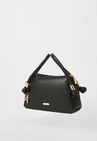 Sac à main en cuir noir avec une forme structurée, petites accents noués sur la poignée, quincaillerie dorée et un détail de logo subtil.