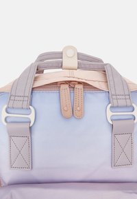 Wielokolorowa torba z miękkim lawendowym tłem i jasnopomarańczowymi akcentami. Gładki materiał z solidnymi szarymi paskami i zapięciem na zatrzask.