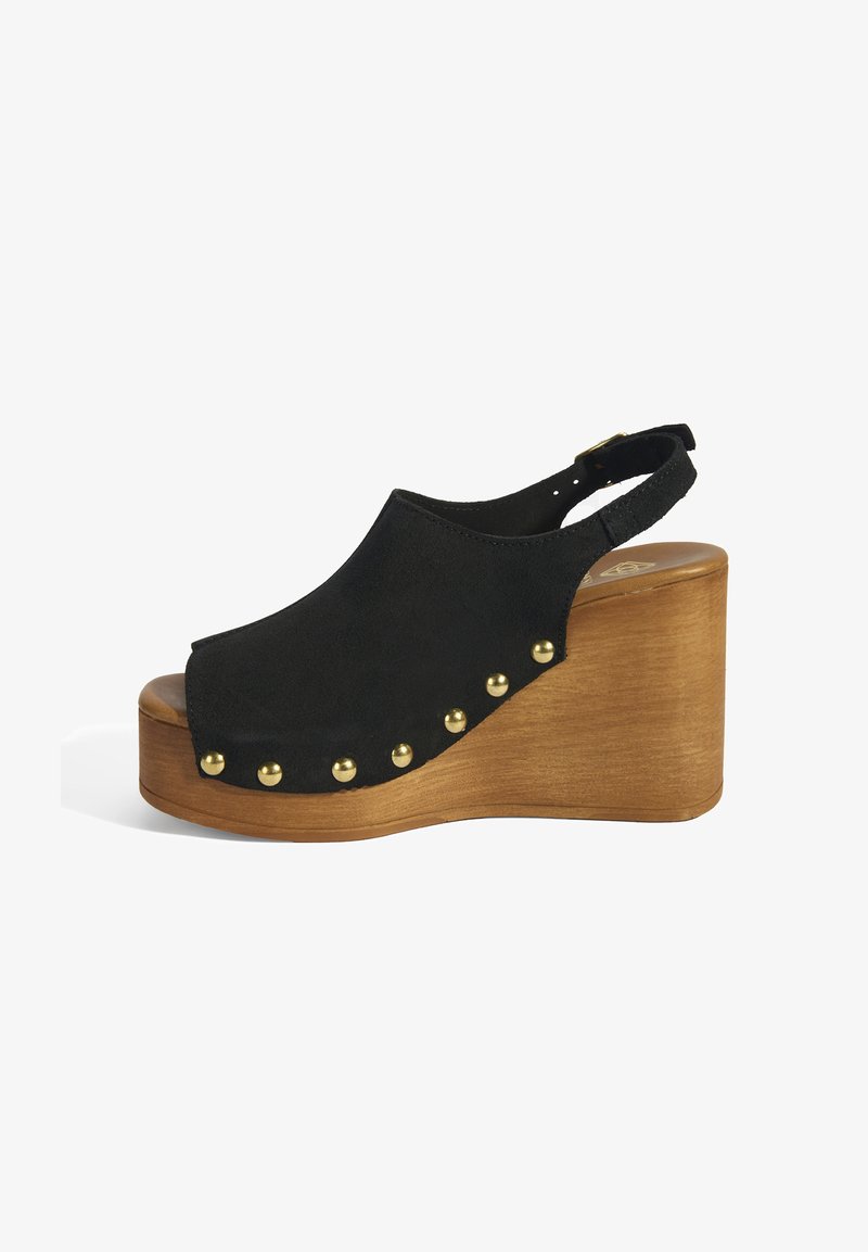 Schwarze Wildleder-Wedge-Sandale mit rundem, offenem Zehenbereich, Holzplattform und goldfarbenen Nieten an der Seite. Verstellbarer Slingback-Riemen.