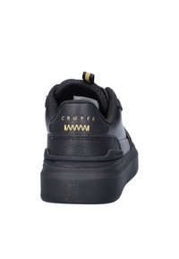 Zwarte leren sneaker met een gestructureerde afwerking, voorzien van een lage profiel, rubberen zool en gouden accent op het logo aan de achterkant.
