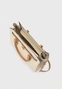 Beige handtas met patroon, bruine leren handvatten, goudkleurige metalen accenten en een ritsvak, met zichtbare binnenvoering.