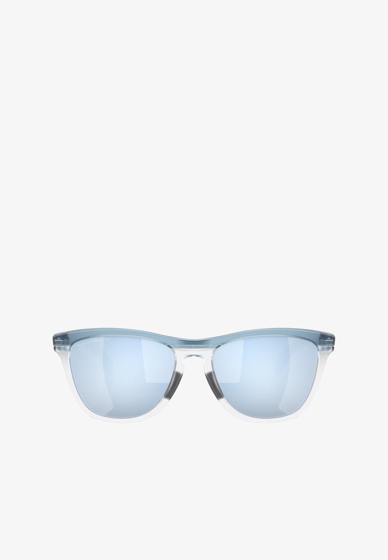 Occhiali da sole tinti di blu con montatura trasparente, forma a occhio di gatto e lenti specchiate. Hardware minimo e superficie liscia.