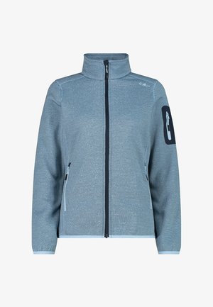 Vaaleansinisestä fleece-takista, jossa on korkea kaulus, metallivetoketju, etutaskut ja tummansininen pätkä, jossa on vetoketjullinen tasku vasemmassa hihassa.