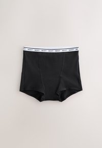 Zwarte boxershorts met een witte elastische tailleband met een herhalend ‘‘NEXT’’-logo, getoond tegen een effen lichte achtergrond.