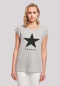 Gray cotton t-shirt with rolled short sleeves, featuring a large black star print and small black stars below it.