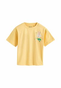 Żółta bawełniana koszulka z krótkimi rękawami. Z przodu znajduje się kolorowa grafika owcy oraz zielone detale trawy. Miękka w dotyku, o luźnym kroju.