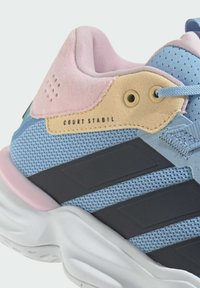Scarpa da allenamento blu con materiale in rete, dettagli rosa e beige, colletto imbottito e strisce nere sul lato. Il testo reca la dicitura "COURT STABIL."
