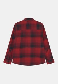 Czerwona i czarna flanelowa koszula w kratę, długie rękawy, standardowy kołnierzyk, mankiety na guziki, proste wykończenie, gładka tekstura. Widok z tyłu.