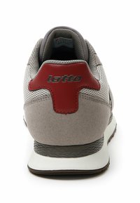 Sneaker in suede grigia e rete con un tacco e un logo accentati in rosso, caratterizzato da una suola testurizzata, un colletto imbottito e una finitura liscia.