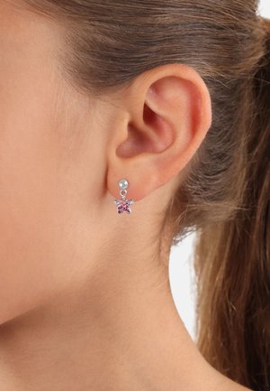 Orecchini a perno a forma di farfalla in argento con centro in pietra rosa e piccolo accentato a sfera, indossati su un orecchio di carnagione chiara.