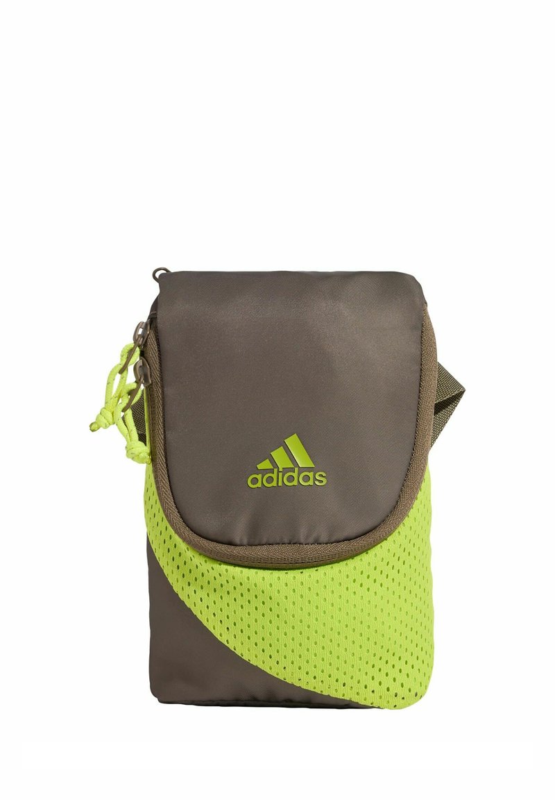 Kleine Adidas Umhängetasche aus braunem Stoff mit neongrünen Mesh-Details, Klappenverschluss und Logo vorne.
