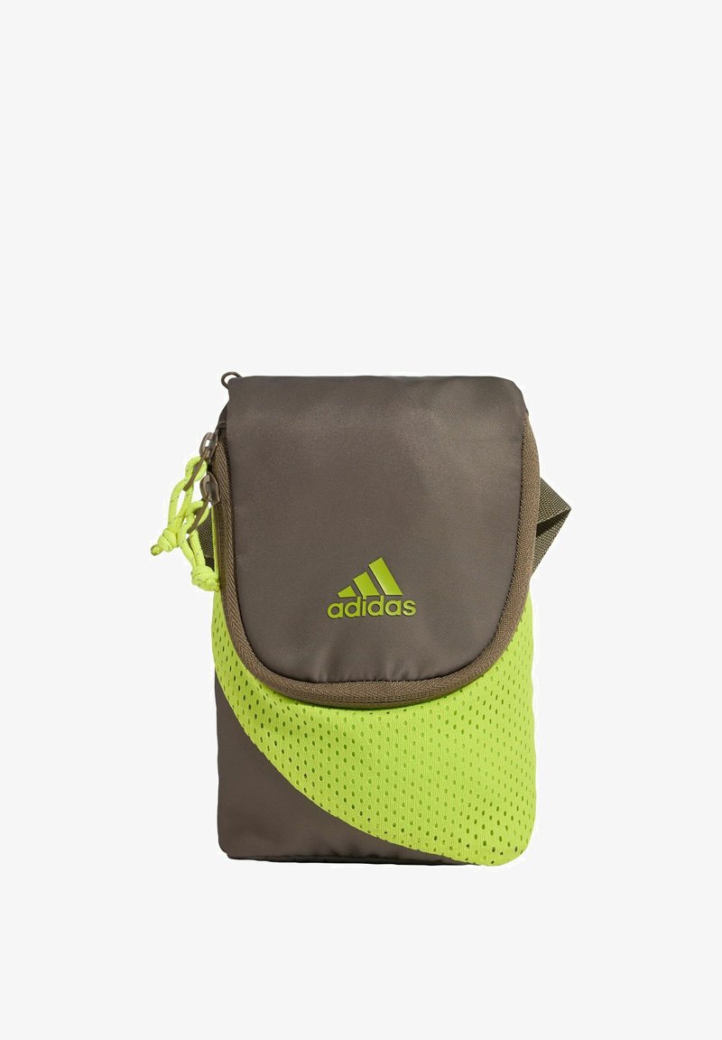 Mala Adidas torbica preko ramena s smeđom tkaninom, neonskim zelenim mrežastim detaljem, preklopnim zatvaranjem i logom sprijeda.