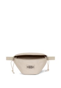 Bustina in tessuto beige con forma arrotondata, chiusura con zip e manico laterale. Presenta una toppa con logo visibile sulla parte anteriore.