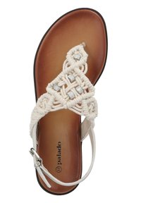 Beżowy sandał makramowy z ozdobami na wierzchu, brązowa wkładka i białe regulowane zapięcie na kostce z srebrną klamrą.