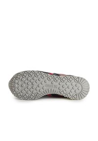 Suela texturizada gris con un diseño de banda de rodadura en patrón. Presenta una marca prominente y acentos multicolores a lo largo de los lados en rojo y negro.