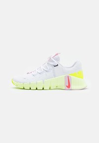 Vit sportskor med rosa och neon gula detaljer, texturerad gummisula och en slank mesh-ovandel. Det unika segmenterade suldesignen förbättrar flexibiliteten.