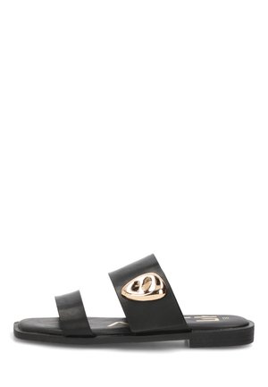 Sandalia plana negra con dos tiras, la delantera lisa y la del medio con un emblema abstracto dorado.