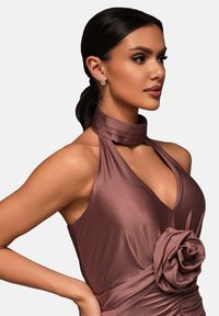 Abito halter neck in raso marrone con un'importante decorazione a rosa in vita, texture liscia e scollatura a V profonda.